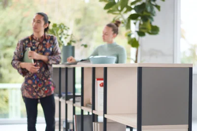 Mann läuft neben einem Büroschrank in einem Büro